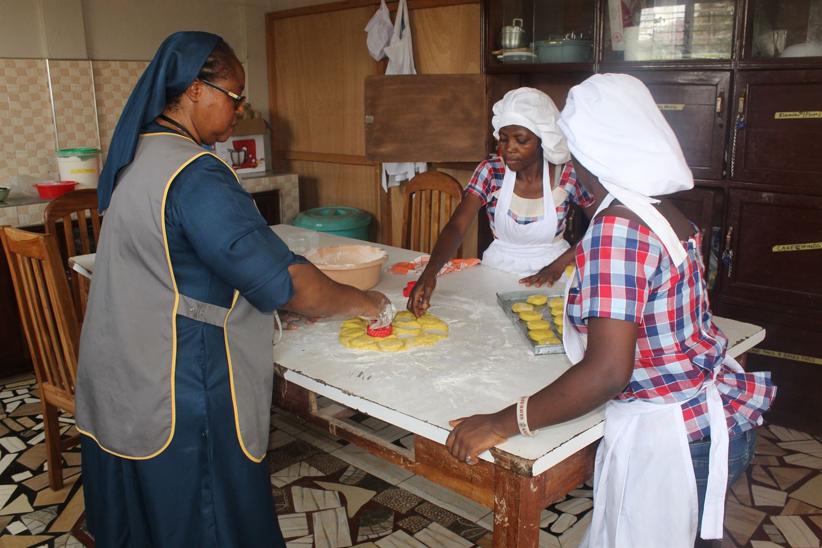Catering instructor guiding learners as they prepare food