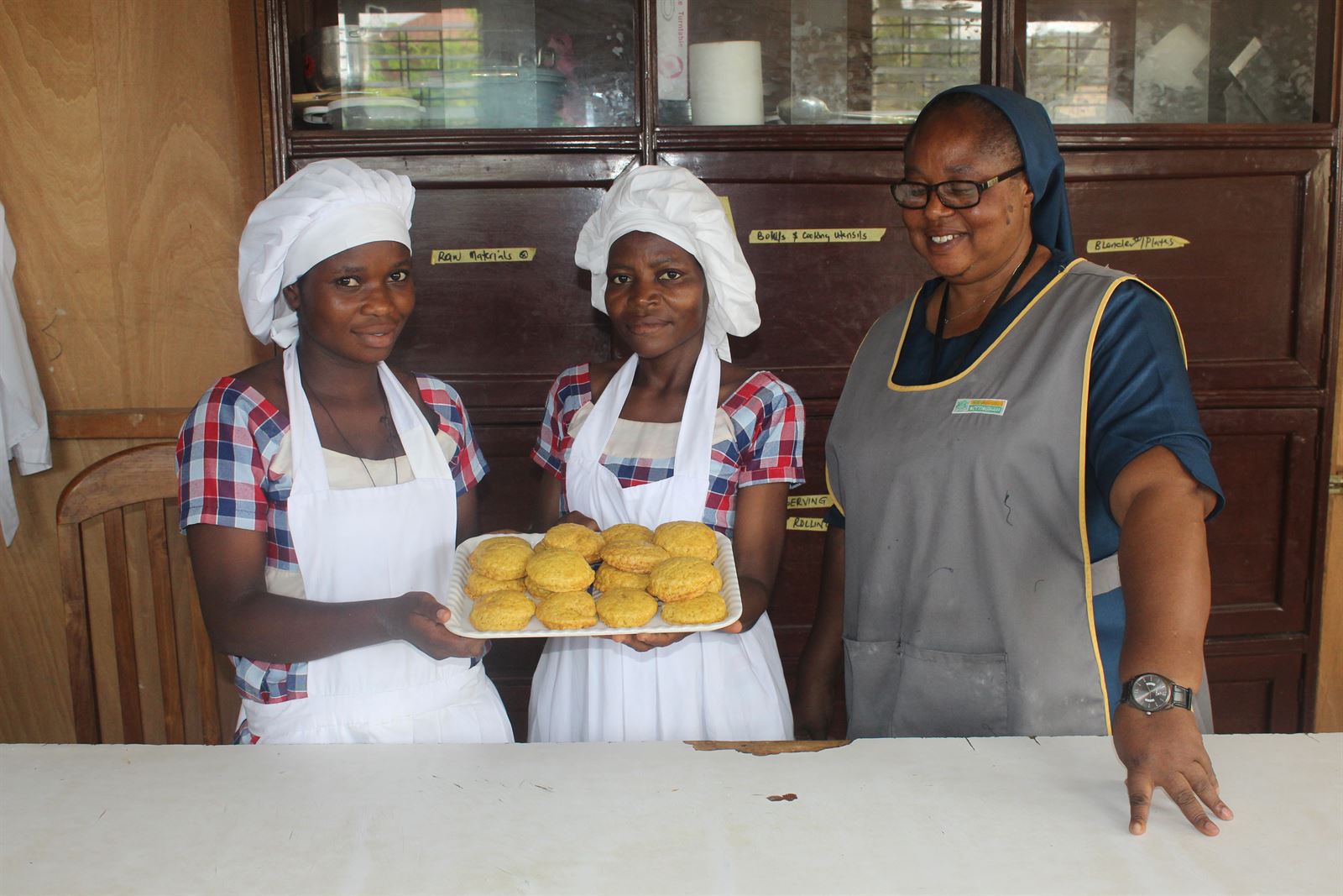 Trainees presenting baked goods with an instructor